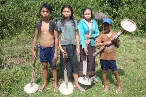 Lao villagers gather scrap metal that may include unexploded ordnance.