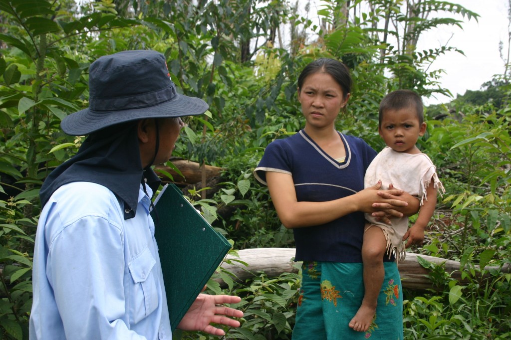 A Lao mother holds her child in a village where unexploded ordnance is being cleared.